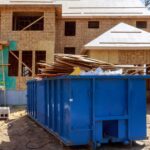 House Under construction with a dumpster full of construction materials